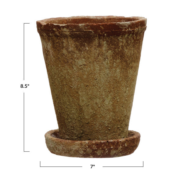 A round terracotta cement planter with a distressed finish and a saucer.
